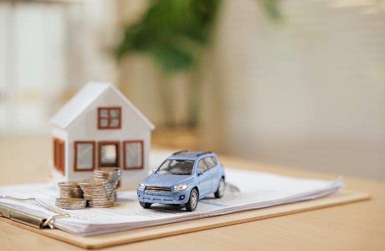 toy car and house with stack of coins