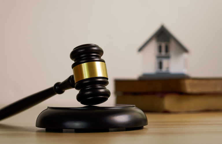 Judge’s gavel with law books and a house